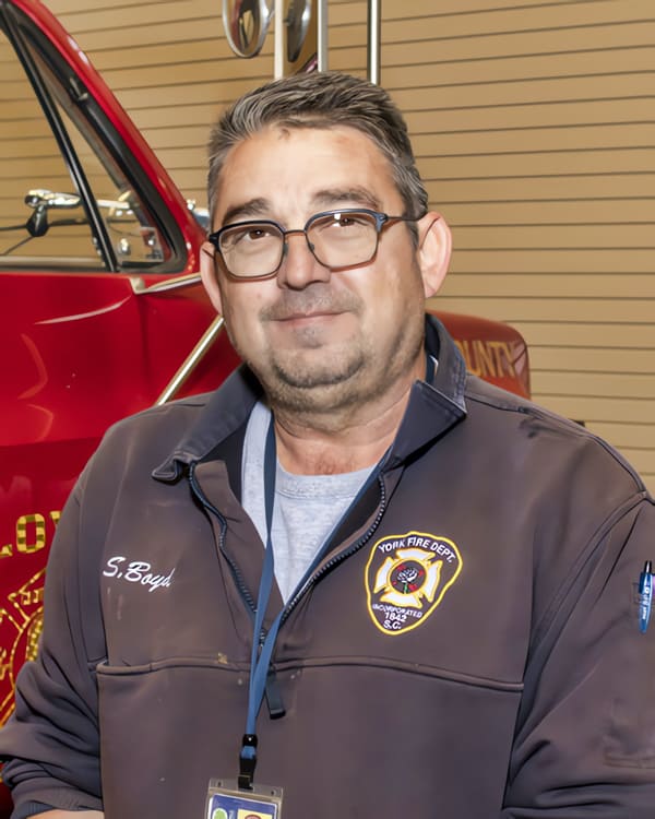 Mr. Boyd in his York Fire Department uniform with a red truck behind him