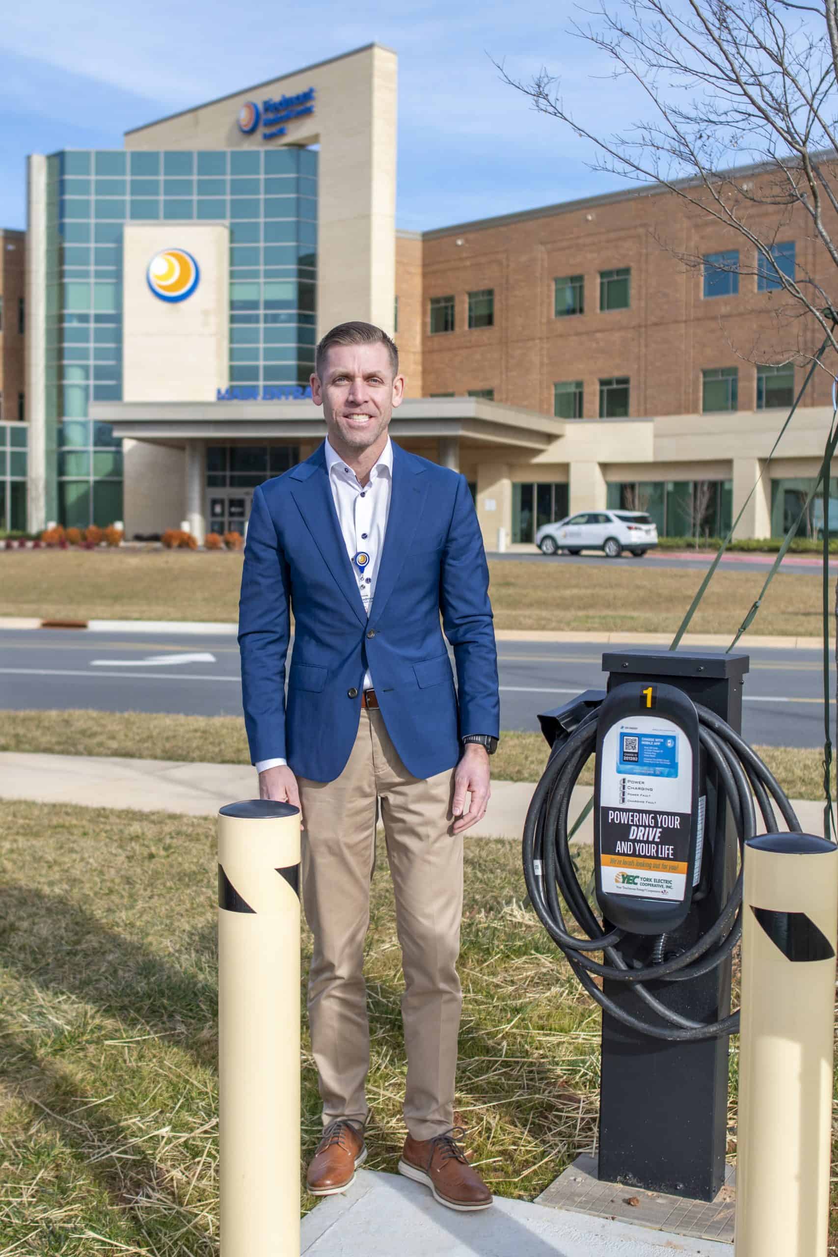 CEO Chris Mitchell stands with the YEC charging station Piedmont Medical Center
