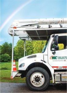 A York Electric utility truck is pictured under a blue sky and a rainbow